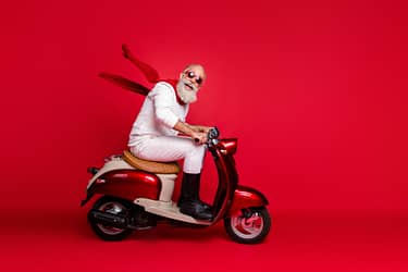 Crazy aged santa man coming, newyear 2020 party by vintage moped wear jumper and trousers isolated red background