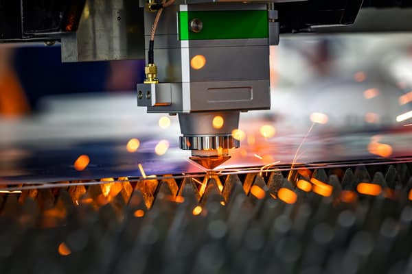 Faserlaser bearbeitet Blech mit Funkenflug: Basis für die Maschinendatenerfassung in der Fertigung
